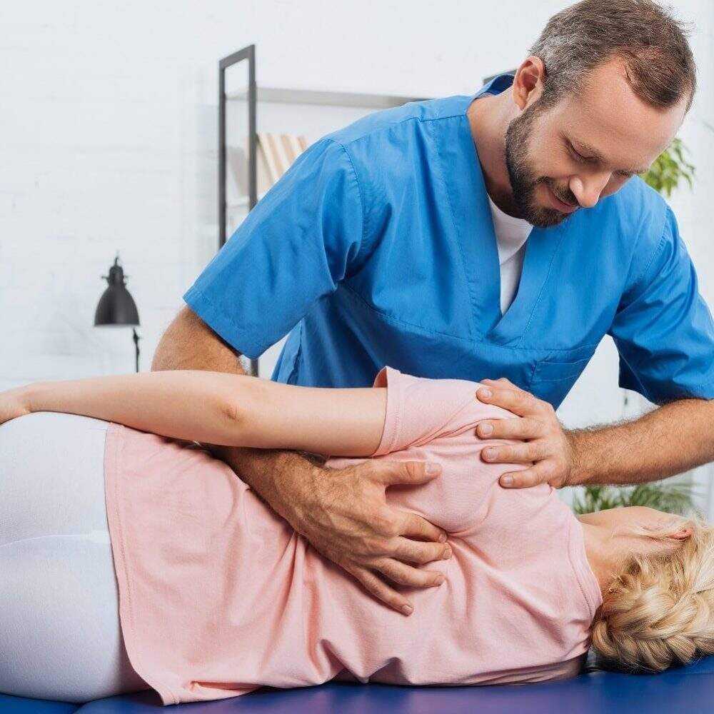 portrait-of-smiling-chiropractor-massaging-back-of-2022-11-02-01-26-39-utc-min-e1684176892945-q6ihrdptc8fmmwq6ssbkfb65lkh1129ravjmea6ej4 (1)